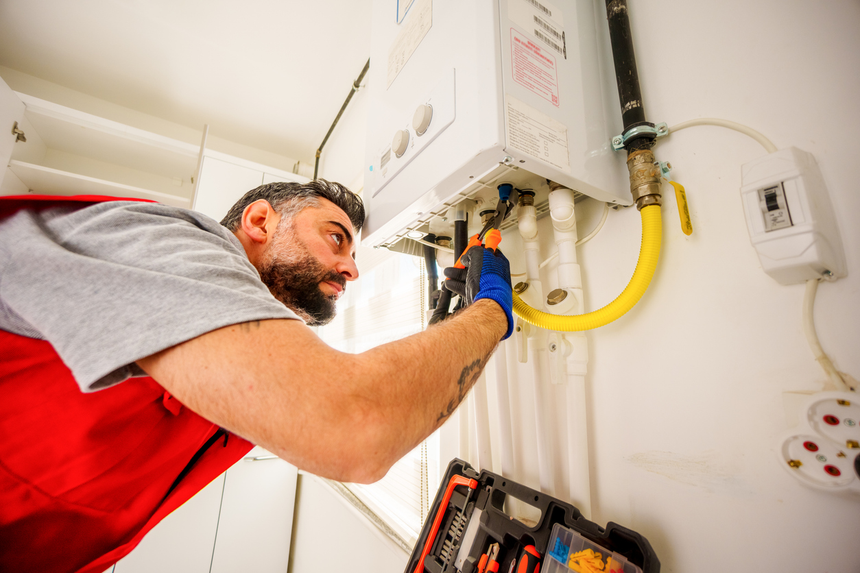 Plumber repairing a boiler with wrench