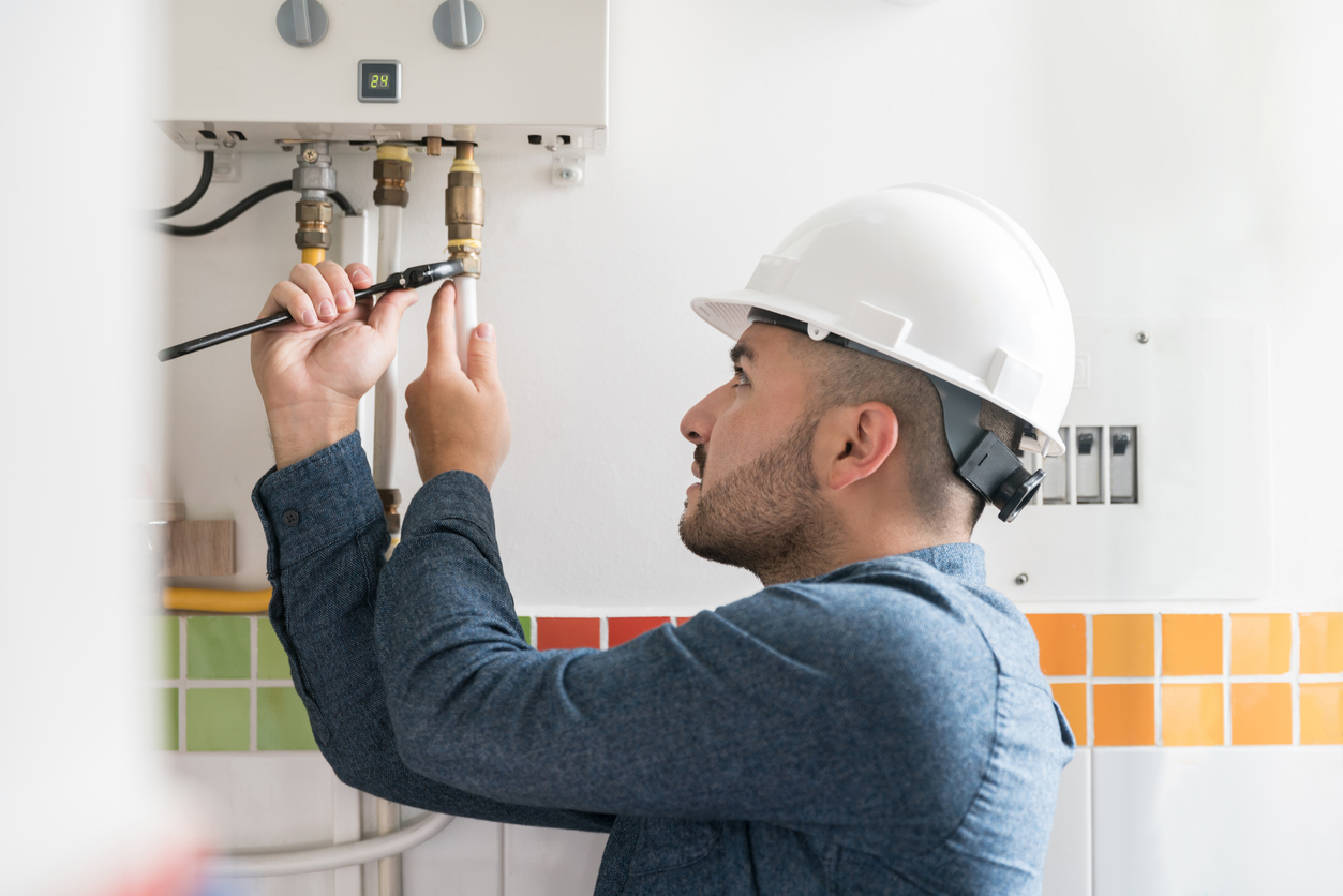 Technician installing a gas boiler in home